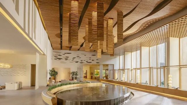 Elegante Lobby mit hängenden Holzinstallationen und großem Brunnen