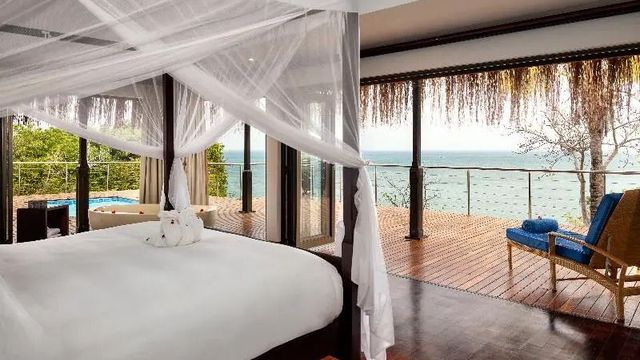 Geräumiges Schlafzimmer mit Himmelbett und Blick auf das Meer vom Balkon