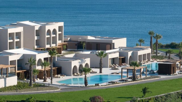 Blick auf das Elissa Lifestyle Beach Resort auf Rhodos mit modernen, flachen Gebäuden, mehreren Pools, Palmen und direkter Lage am Meer mit Blick auf die Küste.