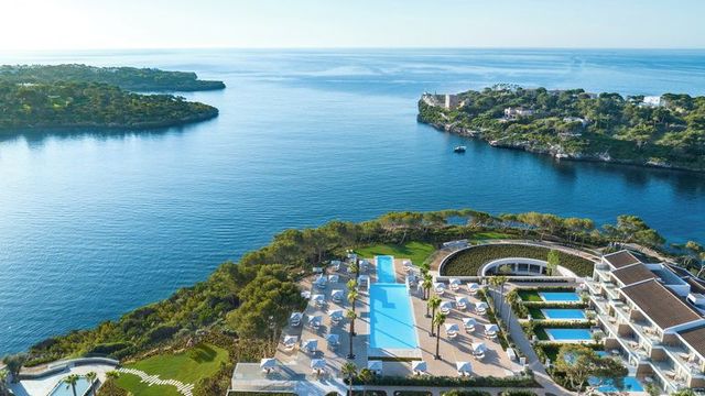 Luftaufnahme des Ikos Porto Petro auf Mallorca mit Blick auf das glasklare Meer, elegante Poollandschaft und moderne Architektur inmitten mediterraner Natur.