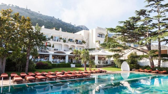 Pool des Jumeirah Capri Palace mit Liegestühlen und das Gebäude