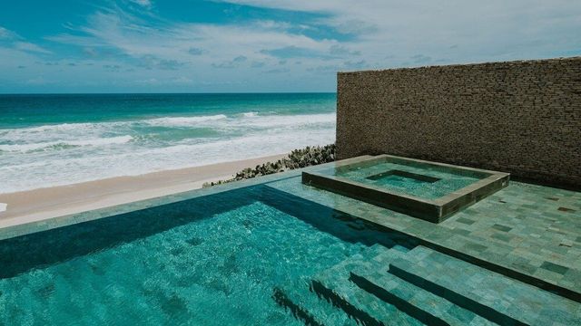 Privater Infinity-Pool und Whirlpool im Kenoa Resort mit direktem Blick auf den Atlantik, perfekte Kulisse für entspannte Momente am Strand.