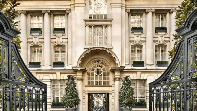 Prächtige Fassade des Rosewood London mit imposanter Eingangstür, symmetrischer Architektur im neoklassizistischen Stil, großen Sprossenfenstern, dekorativen Säulen und schmiedeeisernen Toren im Vordergrund.