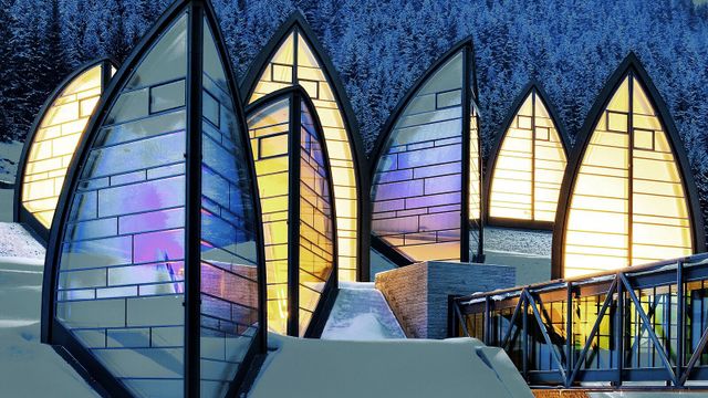 Moderne Architektur mit beleuchteten Glaspaneelen in einer verschneiten Landschaft