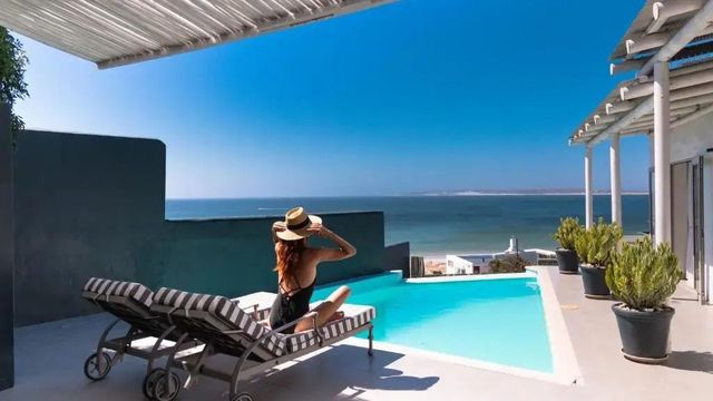 Liegestühle am Pool mit Blick aufs Meer im Abalone Hotel and Villas