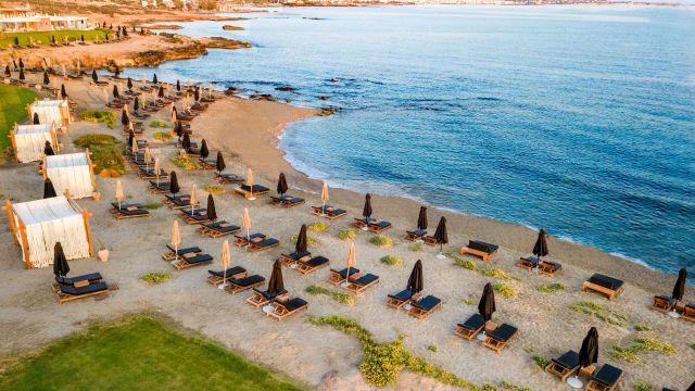 Abaton Island Resort Kreta Strand mit Liegestühlen, Sonnenbetten und Sonnenschirmen