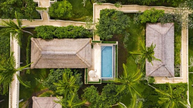 Vogelperspektive auf Villa mit privatem Pool und üppiger Vegetation.