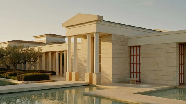 Elegante Hotelarchitektur mit klassisch inspirierten Säulen und ruhigem Wasserbecken