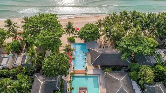 Luftaufnahme des Resorts mit Pool und Strandblick umgeben von tropischen Pflanzen