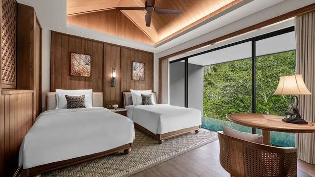 Luxuriöses Doppelzimmer mit Holzdekor und Blick auf private Terrasse mit Pool