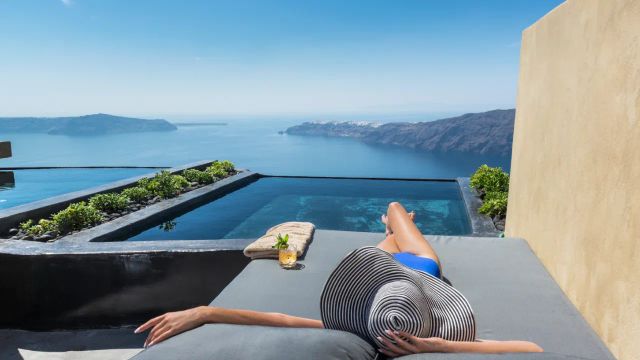 Instagram Model auf Liegestuhl des Andronis Concent mit luxuriösem Meerblick und Pool