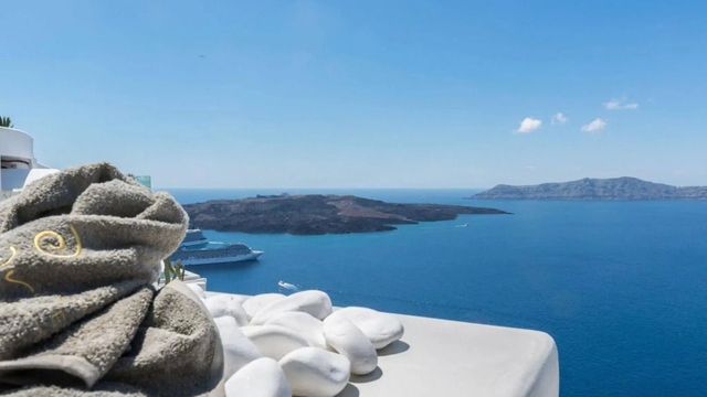 Blick auf das Meer und umliegende Inseln mit weißen Steinen im Vordergrund