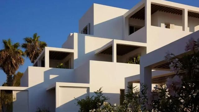 Moderne Architektur mit weißen Fassaden und klaren Linien vor blauem Himmel