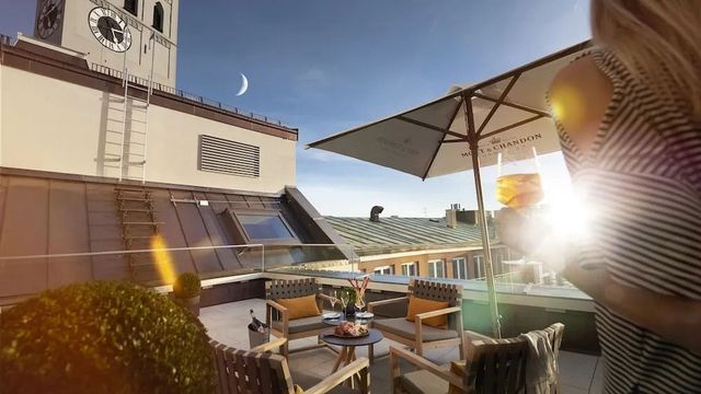Dachterrasse mit Sitzbereich und Sonnenschirm bei Sonnenuntergang