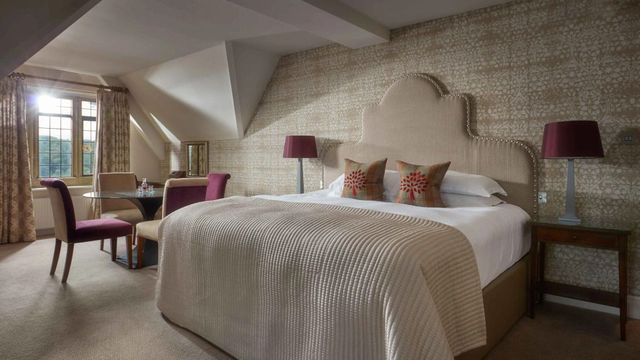 Modernes Dachzimmer mit gemütlichem Doppelbett und schrägen Fenstern.