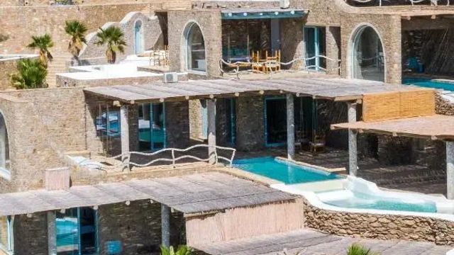 Luxuriöse Hotelgebäude mit privaten Pools und Terrassen, umgeben von Steinarchitektur