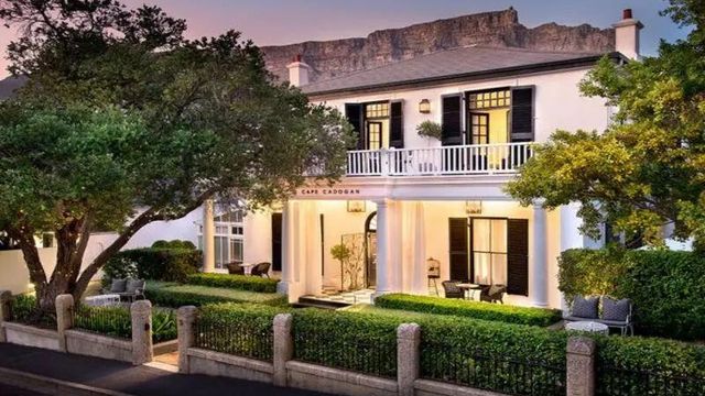 Elegante weiße Fassade des Cape Cadogan Boutique Hotel mit gepflegtem Garten bei Sonnenuntergang.