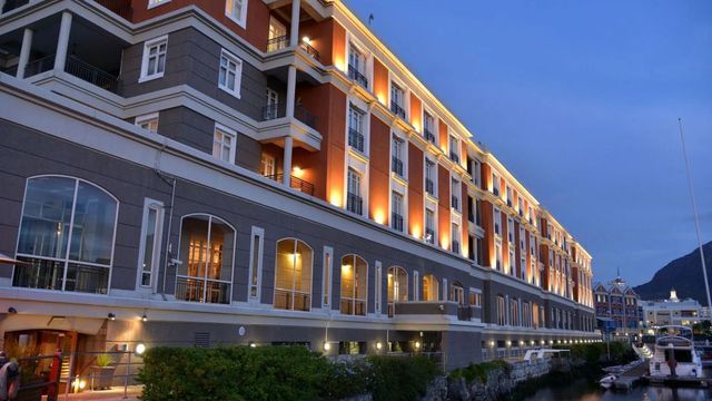 Architektonische Fassade des Cape Grace Hotels bei Abenddämmerung mit stimmungsvoller Beleuchtung.