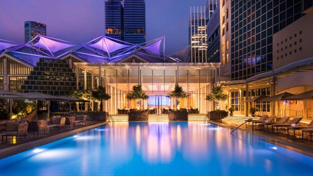 Beleuchteter Außenpool mit architektonischem Highlight im Conrad Singapore Marina Bay