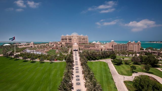 Panoramaansicht des Emirates Palace mit Gärten und Palmenallee
