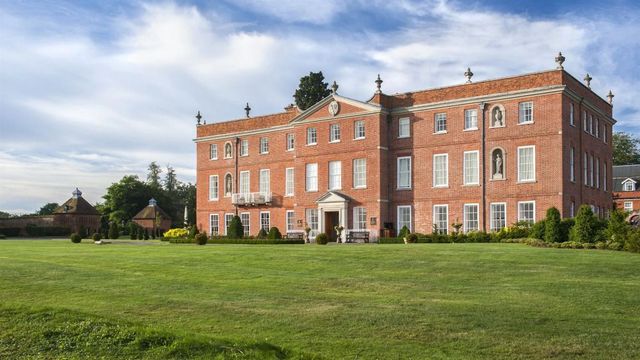 Historische Backsteinfassade des Four Seasons Hotel Hampshire mit gepflegtem Rasen