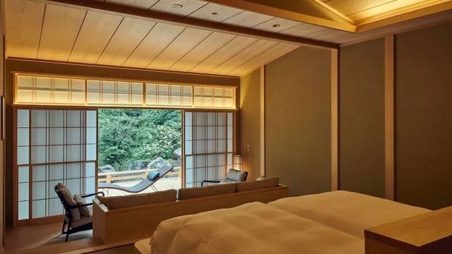 Japanisch inspiriertes Hotelzimmer mit Blick auf die Terrasse und Garten.