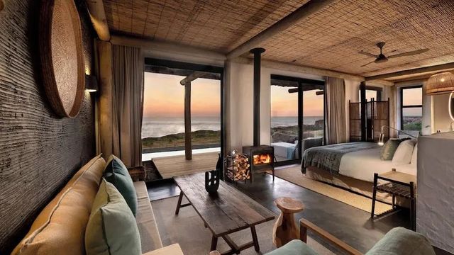 Gemütliches Zimmer mit Kamin und Meerblick bei Sonnenuntergang