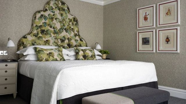 Hotelschlafzimmer mit floralem Kopfteil und stilvoller Dekoration