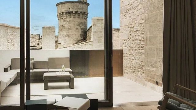 Moderne Terrasse mit Blick auf historischen Turm und Steinmauern