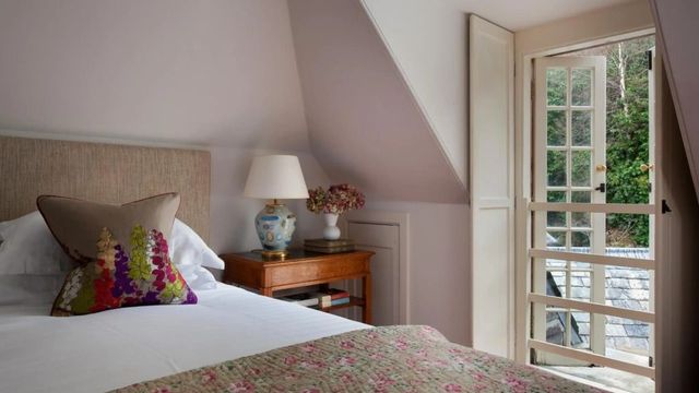 Gemütliches Schlafzimmer mit Dachfenster und floralem Bettüberwurf