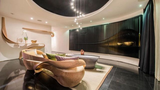 Moderne und stilvolle Hotel-Lounge mit geschwungenen Möbeln und kunstvoller Beleuchtung.