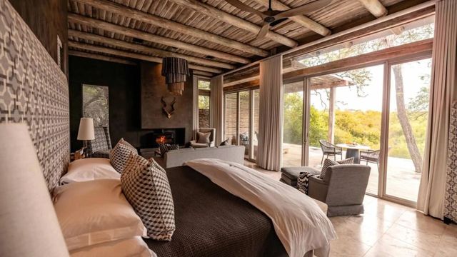 Luxuriöses Schlafzimmer mit großem Bett und Panoramafenster im Hintergrund