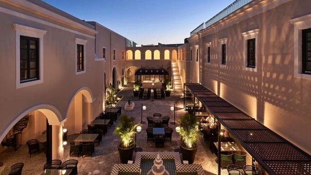 Stimmungsvolle Hotelhofansicht mit abendlicher Beleuchtung und Brunnen