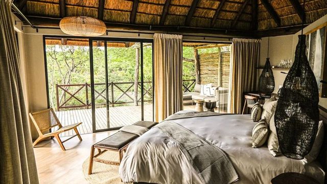 Helles Schlafzimmer mit Zugang zu einem privaten Balkon und Blick ins Grüne