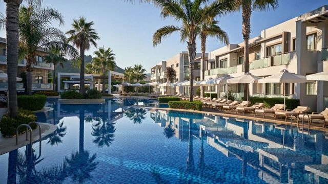 Geräumiger Außenpool mit Palmen und luxuriösen Liegestühlen im Lesante Classic