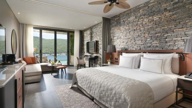 Lujo Hotel Zimmer mit Kingsize Bett und Blick auf das Wasser und die Berge