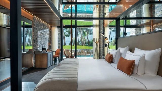 Lujo Hotel Zimmer mit Kingsize Bett und Blick auf Pool und Strand mit Palmen