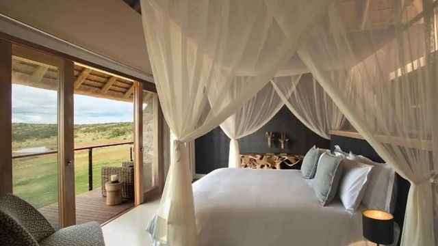 Luxuriöses Schlafzimmer mit Himmelbett und Blick auf die Landschaft