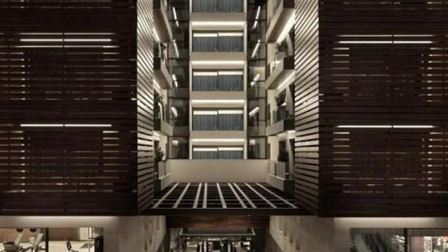 Moderne Hotelfassade mit abendlicher Beleuchtung und Holzelementen