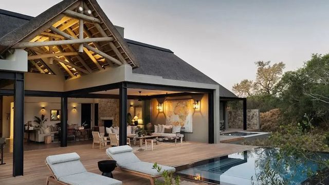 Elegante Barfläche im Freien mit Pool und Liegestühlen, moderne Architektur