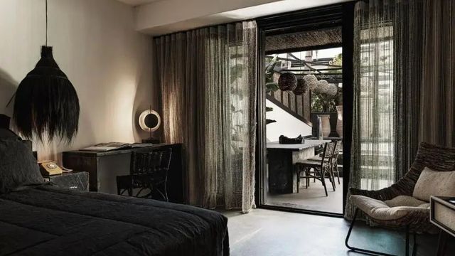 Modernes Hotelzimmer mit Schreibtisch, großem Fenster und Zugang zur Terrasse.