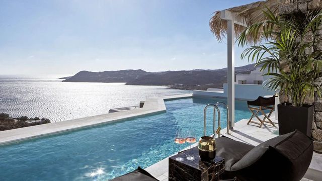 Infinity-Pool mit Meerblick und Sonnenliegen im Myconian Villa Collection Hotel.