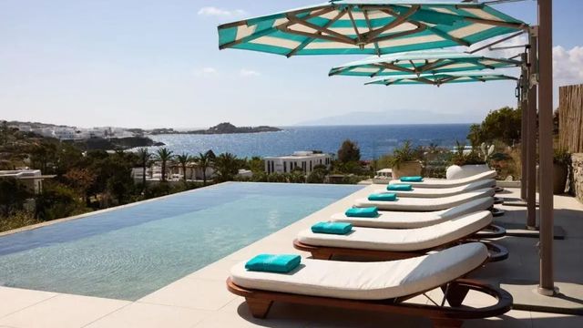 Infinity-Pool mit Liegestühlen und weitem Meerblick