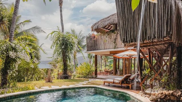 Exklusive Villa mit privatem Pool umgeben von üppiger tropischer Vegetation