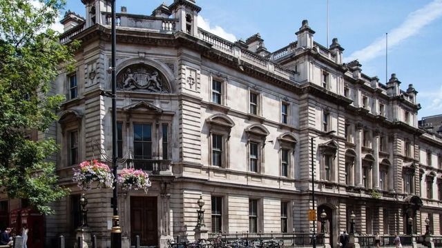 Historische Gebäudefassade mit floralen Dekorationen und Fahrrädern davor