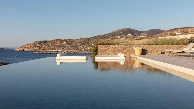 Infinity Pool mit Blick auf die umliegenden Hügel unter klarem Himmel.