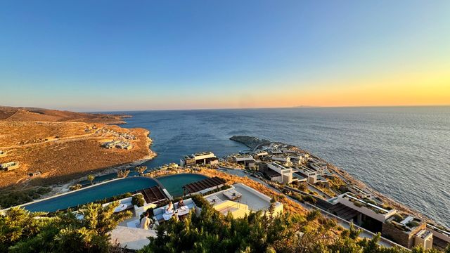 Weitläufige Küstenlandschaft mit Luxusvillen bei Sonnenuntergang und Meerblick.