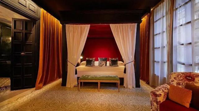 Luxuriöse Master Suite mit Himmelbett und stilvollen Vorhängen