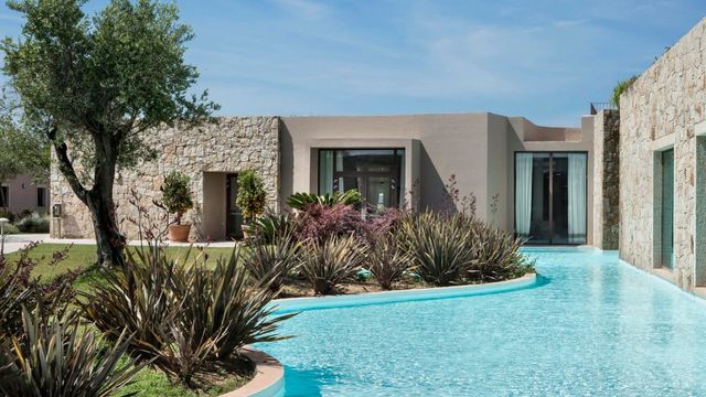 Luxuriöse Villa mit privatem Pool und gepflegtem Garten vor blauem Himmel