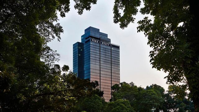 Höher Gebäude des Park Hyatt Jakarta von Bäumen umrahmt